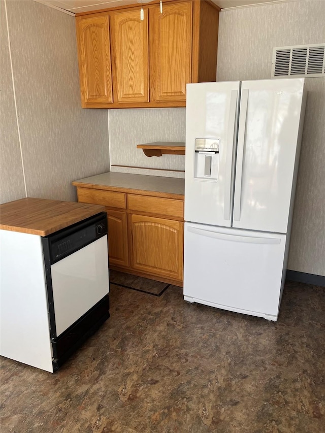 kitchen with white appliances, visible vents, and brown cabinets