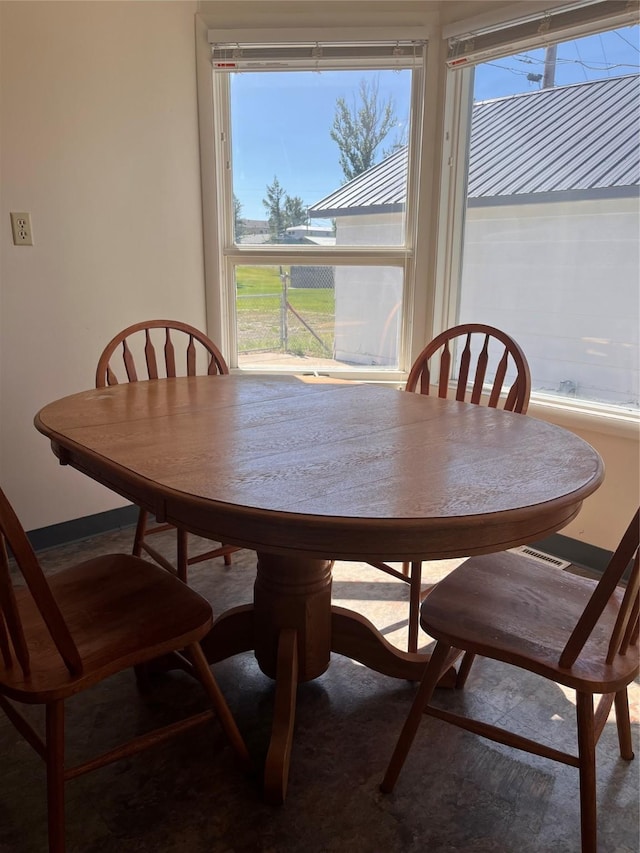 dining space with visible vents, baseboards, and a wealth of natural light