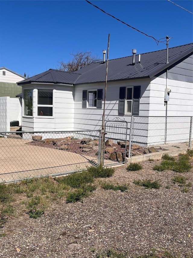 214 3rd St SW, Cut Bank, MT 59427 - view of side of home featuring a metal roof and a gate