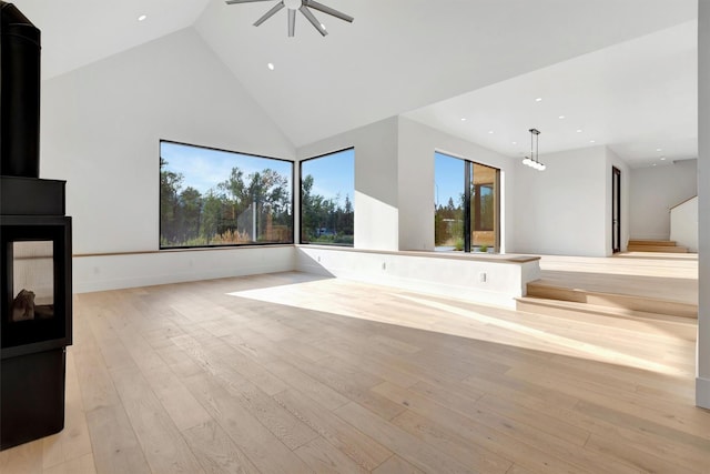 unfurnished living room with high vaulted ceiling, light hardwood / wood-style flooring, and ceiling fan