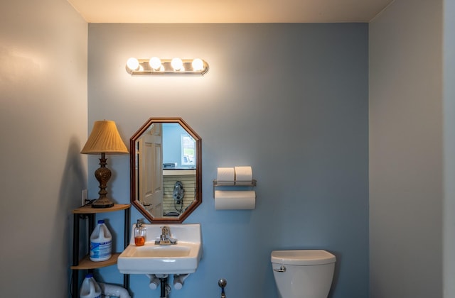 half bathroom featuring toilet and a sink