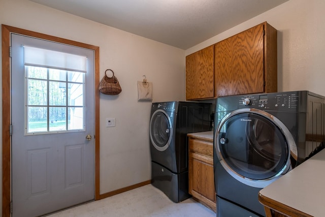 laundry area with washer and dryer, cabinet space, light flooring, and baseboards