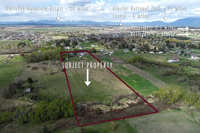 aerial view of property and surrounding area with property boundaries highlighted and mountains