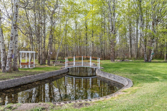 surrounding community with a yard and a forest view