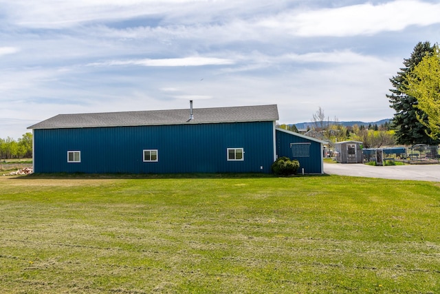 view of side of home featuring a yard, an outbuilding, and an outdoor structure