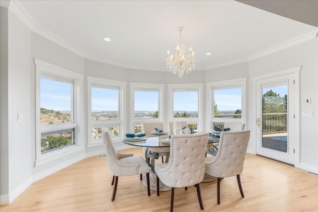 dining space with crown molding, a chandelier, and light hardwood / wood-style floors