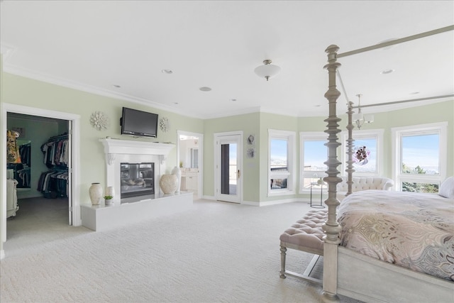 bedroom with ornamental molding, light colored carpet, a walk in closet, and a closet