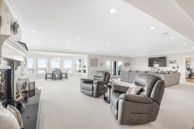 carpeted living room featuring french doors, a chandelier, crown molding, and a premium fireplace