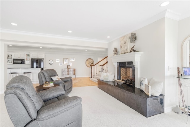 living room featuring a fireplace, light carpet, and ornamental molding