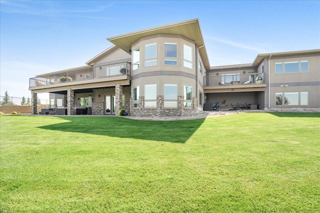 back of house featuring a balcony and a lawn