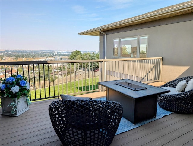 wooden deck featuring a fire pit and a yard