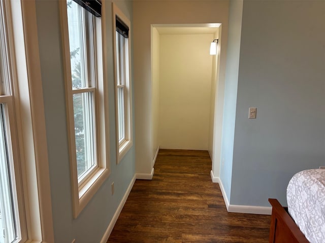 corridor featuring dark wood-style floors and baseboards