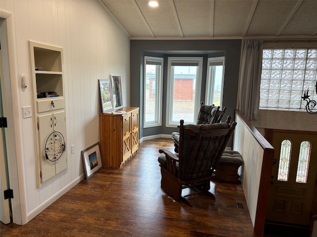 sitting room featuring built in shelves, dark wood-style flooring, and baseboards