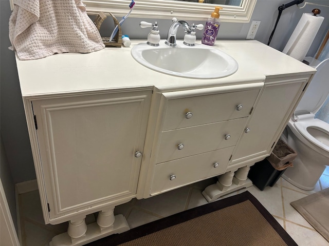 bathroom with toilet, tile patterned flooring, and vanity