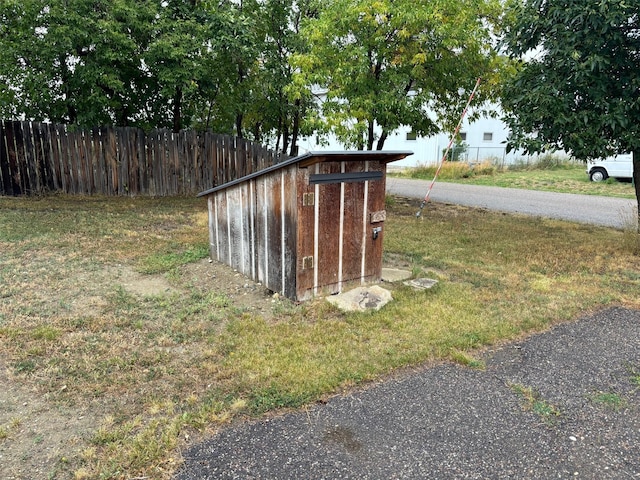 view of outdoor structure with fence and an outbuilding