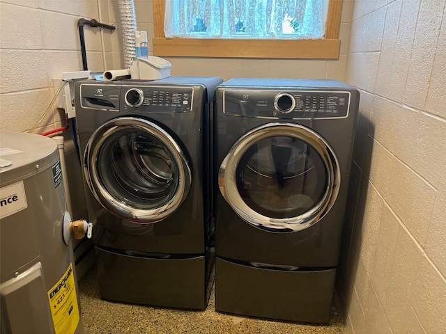 clothes washing area featuring washer and clothes dryer and electric water heater