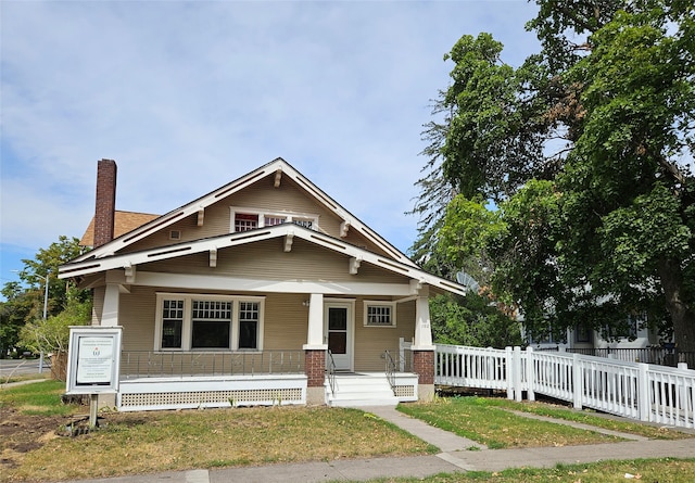 view of front of home featuring covered porch and a front lawn