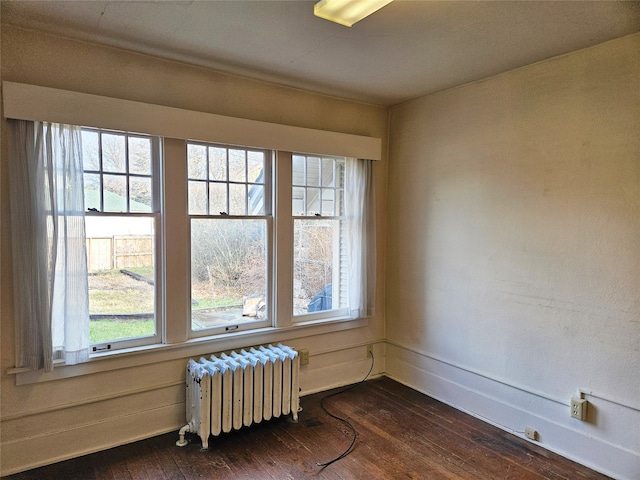 empty room with radiator and dark wood-type flooring