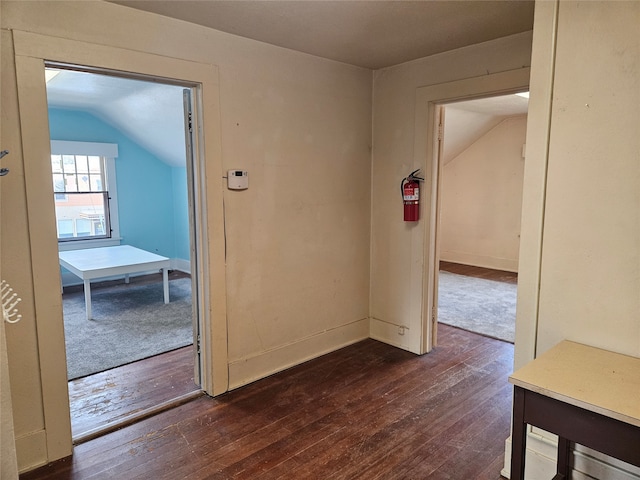 interior space featuring lofted ceiling and dark wood-type flooring