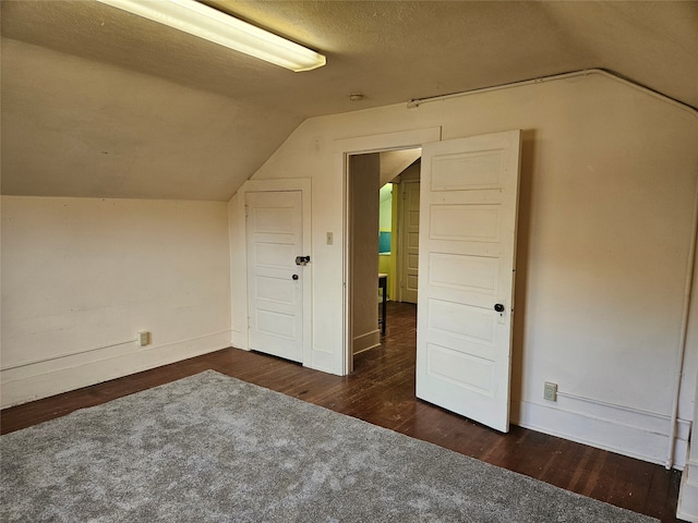 bonus room featuring a textured ceiling, dark hardwood / wood-style floors, and lofted ceiling