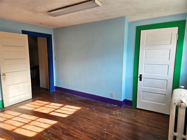 unfurnished bedroom with dark hardwood / wood-style flooring