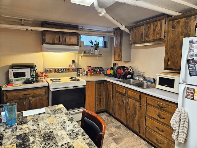 kitchen featuring dark brown cabinets, white appliances, and sink