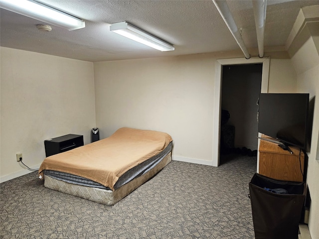 bedroom with beam ceiling, a textured ceiling, and dark colored carpet