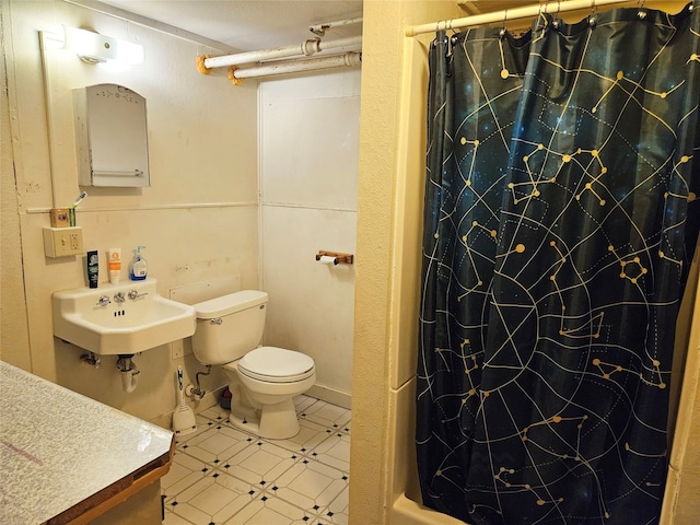 bathroom featuring toilet, curtained shower, and sink