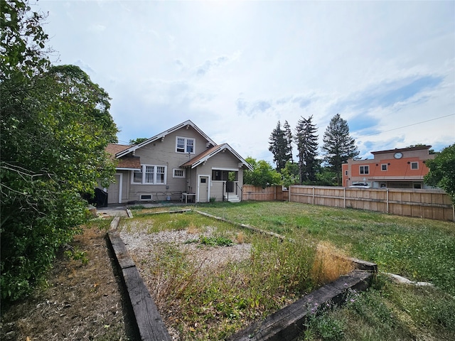 rear view of house featuring a lawn