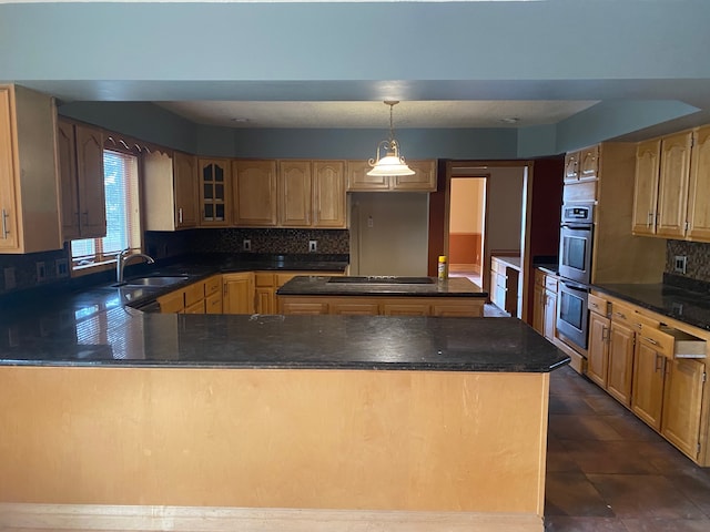 kitchen with backsplash, pendant lighting, black electric cooktop, and sink