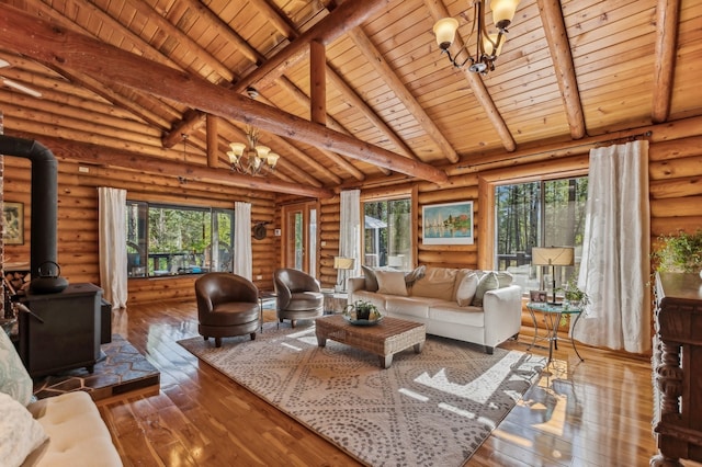 living room with wooden ceiling, a chandelier, a wood stove, and rustic walls