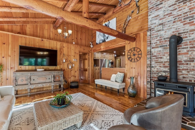 living room with wood ceiling, high vaulted ceiling, hardwood / wood-style flooring, and a wood stove