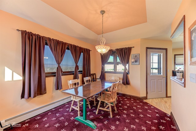 dining room with light wood-type flooring, a tray ceiling, a baseboard radiator, and an inviting chandelier