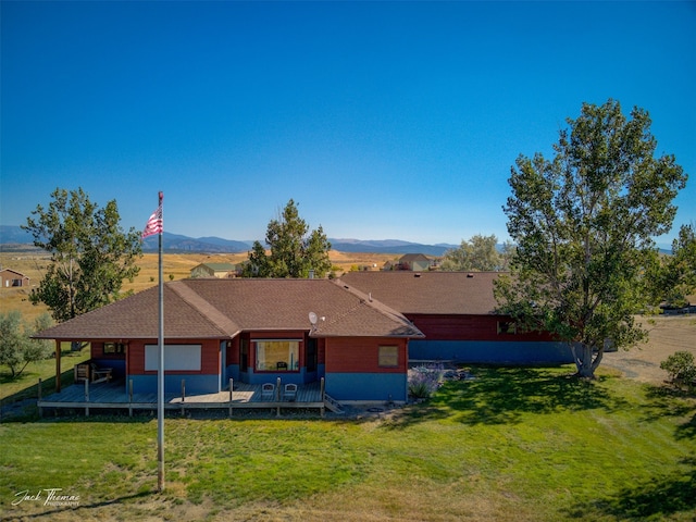 rear view of property featuring a lawn and a mountain view