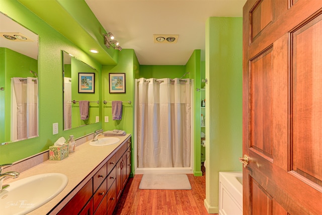 bathroom featuring vanity, wood-type flooring, and shower with separate bathtub