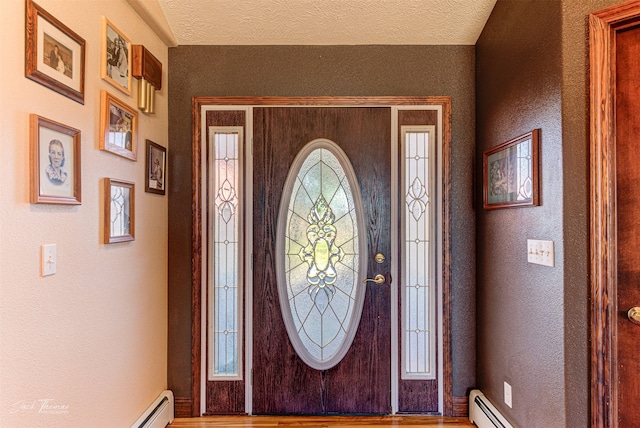 entrance foyer with hardwood / wood-style flooring, a textured ceiling, and a healthy amount of sunlight