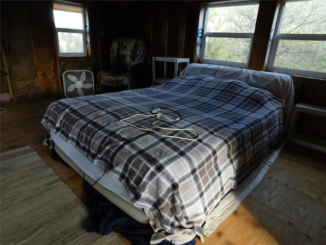 bedroom with hardwood / wood-style flooring and multiple windows