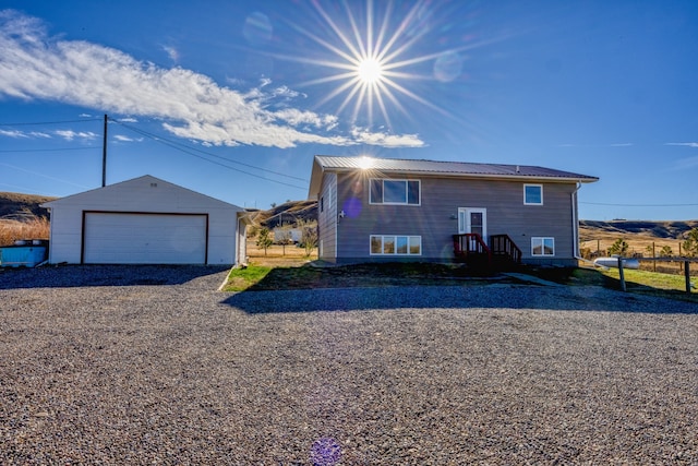 view of front of home with a garage and an outbuilding