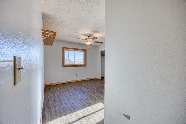 unfurnished room featuring a textured ceiling, hardwood / wood-style flooring, and ceiling fan