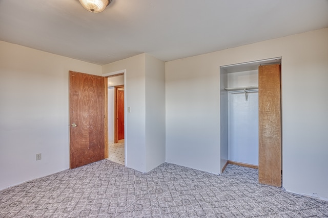 unfurnished bedroom featuring a closet and light colored carpet