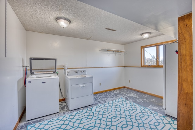 laundry area featuring washing machine and dryer and a textured ceiling