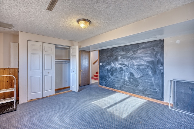 carpeted bedroom featuring a textured ceiling and a closet