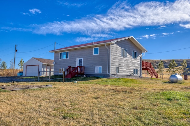 back of house featuring a garage and a lawn