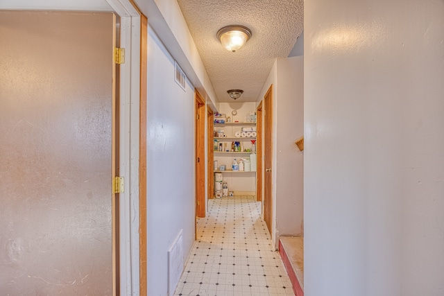 corridor featuring a textured ceiling