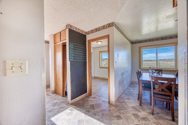 dining space with hardwood / wood-style flooring and a textured ceiling