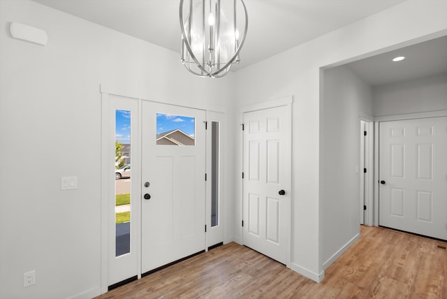 foyer entrance featuring an inviting chandelier and light wood-type flooring