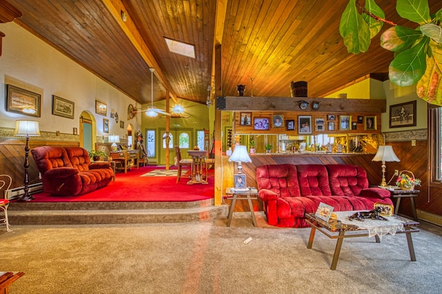 carpeted living room with wood walls, a baseboard radiator, wood ceiling, high vaulted ceiling, and a skylight