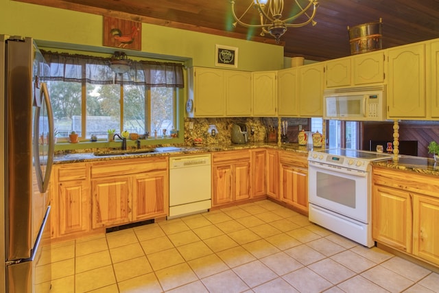 kitchen featuring light tile patterned floors, white appliances, a chandelier, and sink