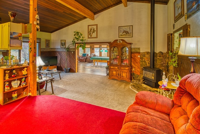 living room with a wood stove, carpet, beamed ceiling, and high vaulted ceiling