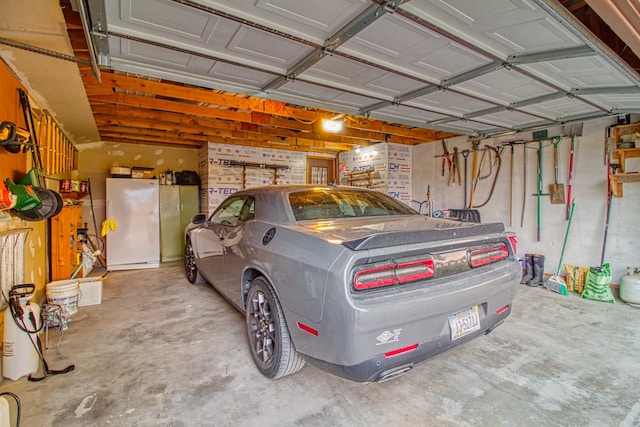 garage with a garage door opener and white fridge